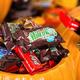 Halloween candy (Milky Way, Twix, Kit Kat, Snickers) in decorative pumpkin
